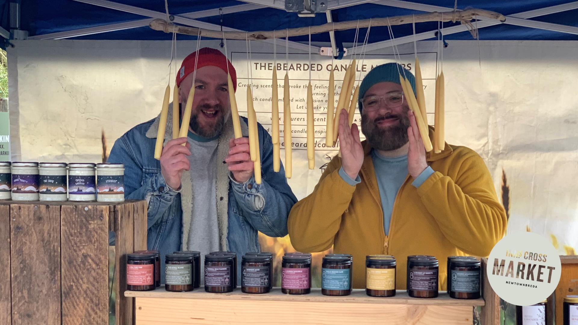 Two stall holders holding candles