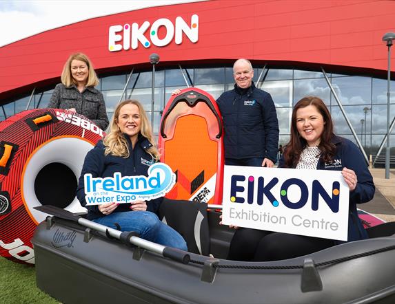 Image is of the organisers of the Ireland on the Water Expo in a dinghy and holding a surfboard outside the Eikon Exhibition Centre