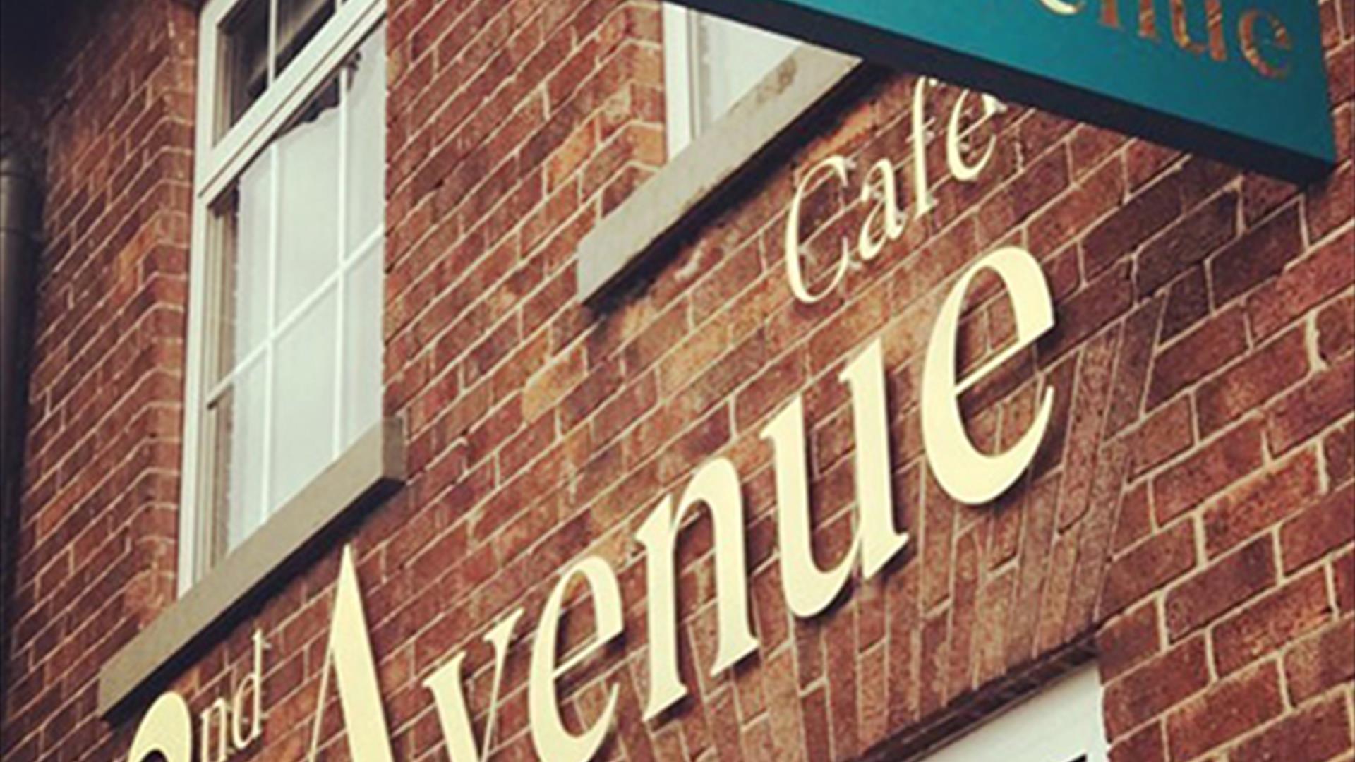 Image shows front of 2nd Avenue Cafe with named sign