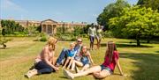 Family sitting on grass with Hillsborough Castle in background
