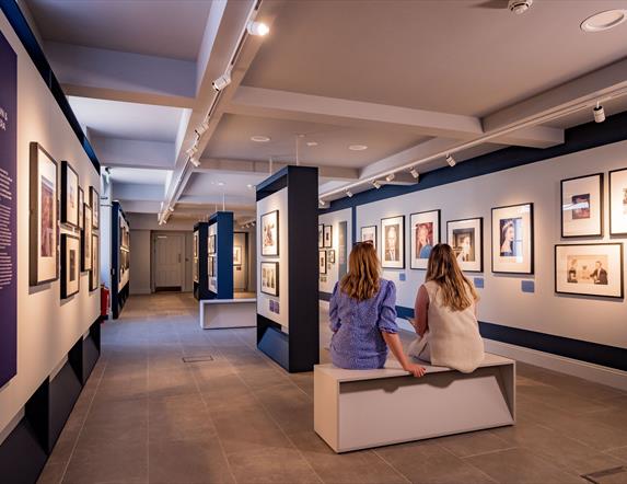 Visitors sitting at the Life Through A Royal Lense Exhibition