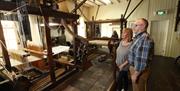 Couple standing in the museum looking at the looms