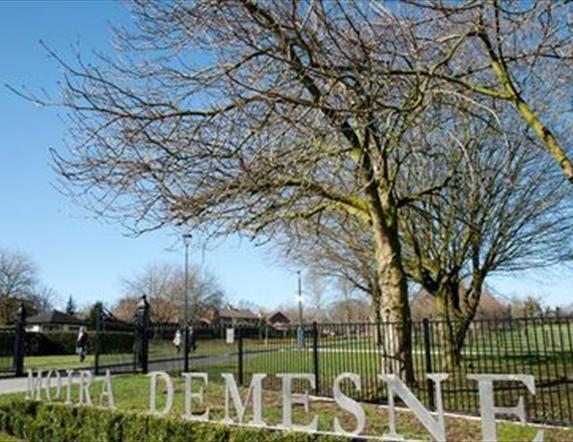 Sign stating Moira Demesne with trees in the background
