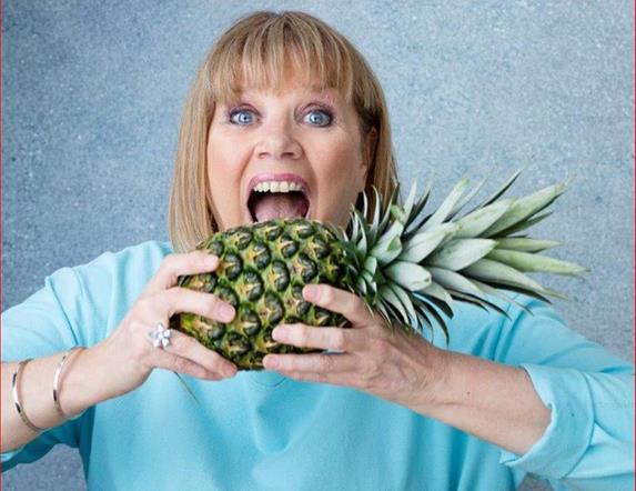 Image is of Nuala McKeever attempting to eat a pineapple