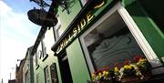 Image is of the front of the pub with flower baskets on the window sill