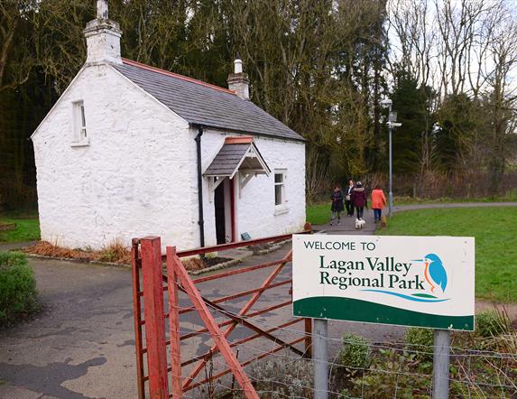 Image shows entrance to the Lagan Valley Regional Park with a white cottage in the background