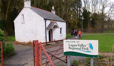 Image shows entrance to the Lagan Valley Regional Park with a white cottage in the background