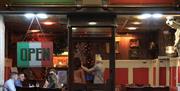 Image is of the entrance of Tutta La Pizza showing customers inside