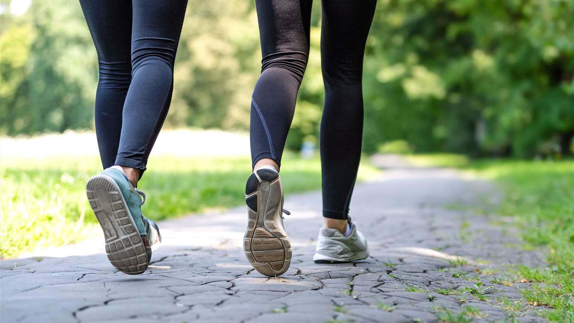 Image is a generic one of 2 pairs of lower legs walking on the pavement