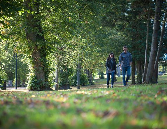 Image shows a woman and man walking in Wallace Park