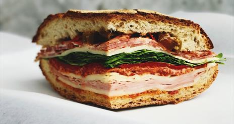 Image shows a sandwich with ham, chicken, bacon lettuce & tomato